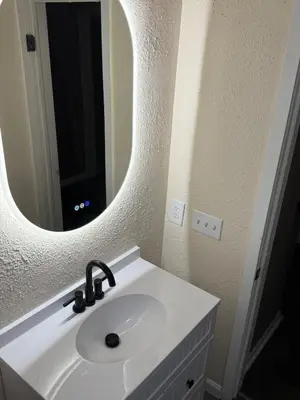 a bathroom with a white sink and a mirror at The Gather Grove in Toledo