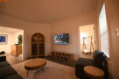 a living room with a couch and a tv on the wall at Edgewater Stay on W78th in Cleveland