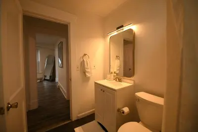 a bathroom with a toilet and a sink and a mirror at Edgewater Stay on W78th in Cleveland