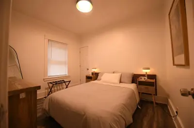 a bedroom with a bed and two chairs and a window at Edgewater Stay on W78th in Cleveland