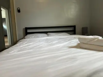 a white bed with white sheets and pillows on it at Great Room near Cleveland airport in Cleveland