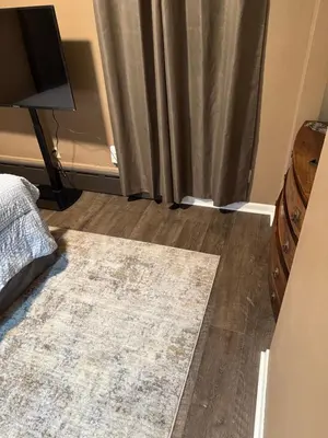 a bedroom with a rug on the floor and a curtain at The Unity Hub in Toledo