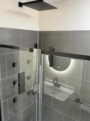 a bathroom with a shower with a sink and a mirror at The Unity Hub in Toledo