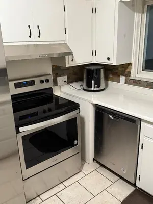 a kitchen with white cabinets and a stove top oven at The Unity Hub in Toledo