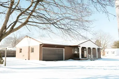 a house with a garage in the snow at Mid Ohio Comfort 10 Minutes From Snow Trails in Lexington