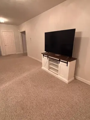a living room with a flat screen tv on a wall at Downstairs oasis