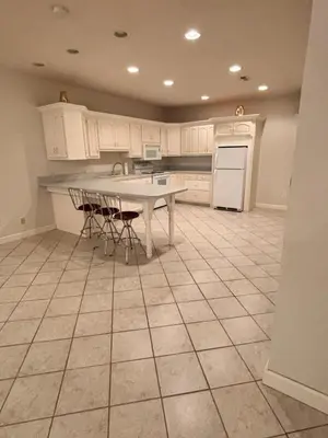a kitchen with a table and some chairs in it at Downstairs oasis