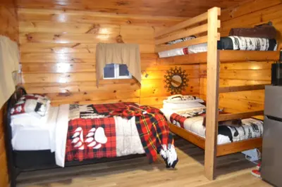 a bedroom with two bunk beds in a log cabin at Campfire Cabin, Red River Gorge, KY, River Access & Views in Stanton