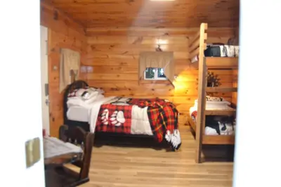 a bedroom with a bed in a log cabin at Campfire Cabin, Red River Gorge, KY, River Access & Views in Stanton