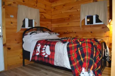 a bedroom with a bed in a log cabin at Campfire Cabin, Red River Gorge, KY, River Access & Views in Stanton