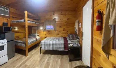 a bedroom with a bed in a wooden cabin at Sleepy Bear Cabin, Red River Gorge, KY, River Access & Views in Stanton