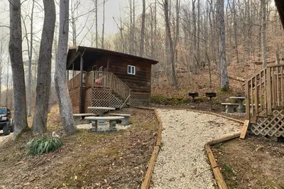 a cabin in the woods with benches and a walkway at Sleepy Bear Cabin, Red River Gorge, KY, River Access & Views in Stanton