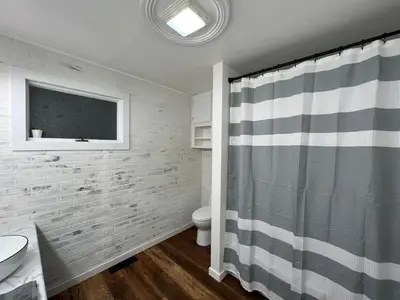 a bathroom with a shower curtain and a toilet at Scippo Creek Farm in Circleville