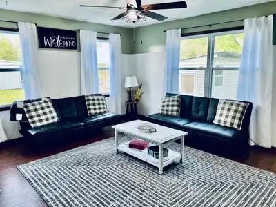 a living room with black leather couches and a table at Scippo Creek Farm in Circleville