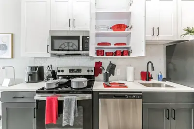 a kitchen with white cabinets and a stove top oven at Walk to Bengal, Reds Free Parking King Bed Gym in Cincinnati