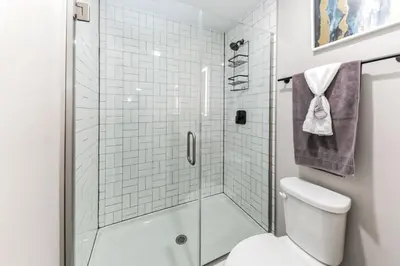 a white bathroom with a shower and a toilet at Walk to Bengal, Reds Free Parking King Bed Gym in Cincinnati