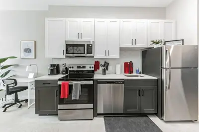 a kitchen with stainless steel appliances and white cabinets at Walk to Bengal, Reds Free Parking King Bed Gym in Cincinnati