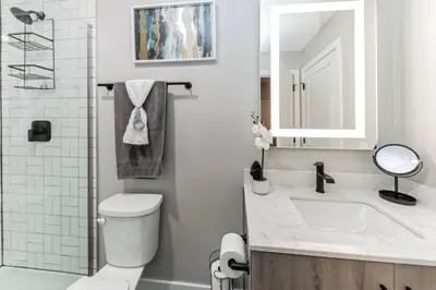 a bathroom with a toilet and a sink and a mirror at Walk to Bengal, Reds Free Parking King Bed Gym in Cincinnati
