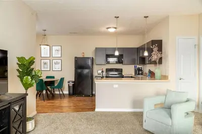 a kitchen and living room with a couch and a chair at The New Albany Perch Top Floor Pet-Friendly! in Westerville