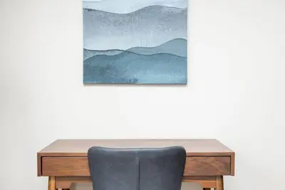 a wooden desk with a chair in front of a wall at The New Albany Perch Top Floor Pet-Friendly! in Westerville