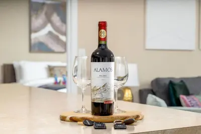 a bottle of wine on a table with two wine glasses at The New Albany Perch Top Floor Pet-Friendly! in Westerville