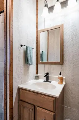 a bathroom with a sink and a mirror at Peaceful Valley Retreat in Sugarcreek