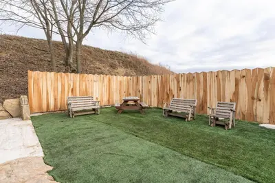 two benches and a picnic table next to a fence at Peaceful Valley Retreat in Sugarcreek