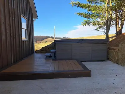 a wooden deck with a bench next to a building at Peaceful Valley Retreat in Sugarcreek