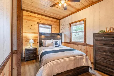 a bedroom with a bed in a log cabin at Peaceful Valley Retreat in Sugarcreek