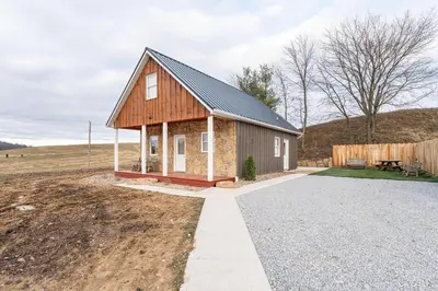 a small house in the middle of a field at Peaceful Valley Retreat in Sugarcreek