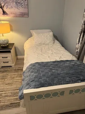 a bedroom with a bed and a night stand with a lamp at Pennsboro WV 'Country Roads' in Pennsboro