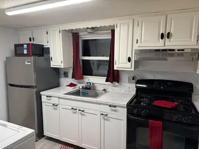 a kitchen with white cabinets and a black stove top oven at Pennsboro WV 'Country Roads' in Pennsboro