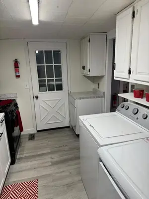 a kitchen with white cabinets and a white door at Pennsboro WV 'Country Roads' in Pennsboro