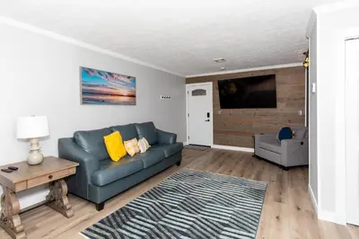 a living room with a blue couch and a tv at NEW! Remodeled & Upgraded Vacation Apartment in Sandusky
