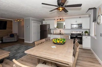 a kitchen and dining room with a wooden table at NEW! Remodeled & Upgraded Vacation Apartment in Sandusky