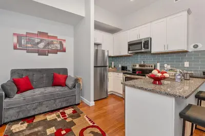 a living room with a couch and a kitchen at OTR's Hidden Gem in Cincinnati