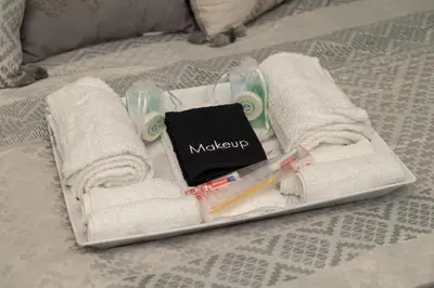 a tray with towels and a book on a bed at OTR's Hidden Gem in Cincinnati