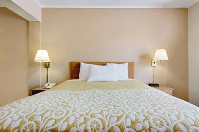 a hotel room with a large bed with two lamps at Days Inn by Wyndham Fairmont in Fairmont