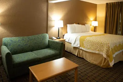 a hotel room with a bed and a chair at Days Inn by Wyndham Fairmont in Fairmont