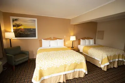 a hotel room with two beds and a chair at Days Inn by Wyndham Fairmont in Fairmont