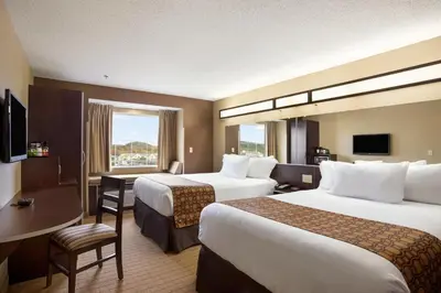 a hotel room with two beds and a desk at Microtel Inn & Suites by Wyndham Cambridge in Cambridge