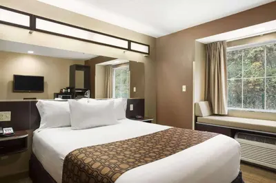 a hotel room with a large bed and a window at Microtel Inn & Suites by Wyndham Cambridge in Cambridge