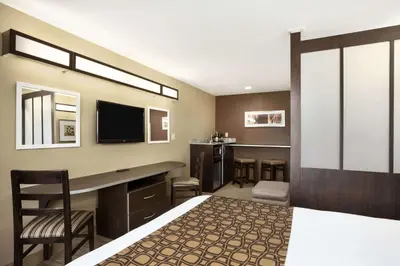 a bedroom with a bed and a desk and a tv at Microtel Inn & Suites by Wyndham Cambridge in Cambridge