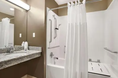 a bathroom with a shower and a sink at Microtel Inn & Suites by Wyndham Cambridge in Cambridge