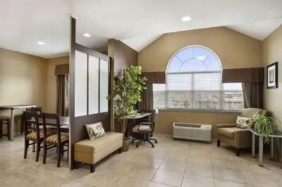 a waiting room with a table and chairs at Microtel Inn & Suites by Wyndham Cambridge in Cambridge