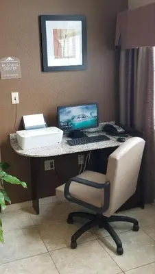 a desk with a computer and a chair in a room at Microtel Inn & Suites by Wyndham Cambridge in Cambridge