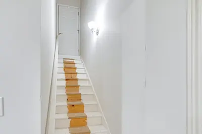 a staircase in a white room with wooden floors at 6 Mi to Town Peaceful Lima Home! in Lima