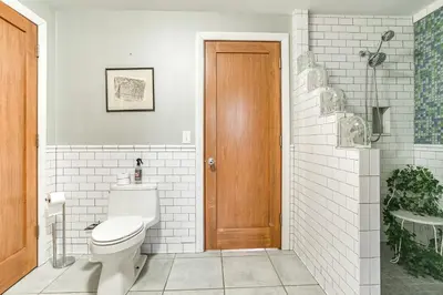 a bathroom with a toilet and a wooden door at Less Than 1 Mi to Wittenberg Eclectic Loft with Parking! in Springfield