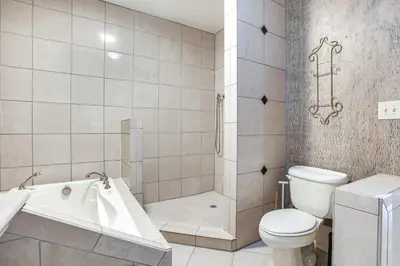 a bathroom with a toilet and a tub and a shower at Less Than 1 Mi to Wittenberg Eclectic Loft with Parking! in Springfield