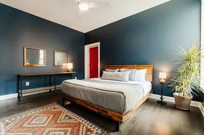 a bedroom with a bed and a blue wall at Lux Washington-Park Rooftop Patio-Free Parking in Cincinnati
